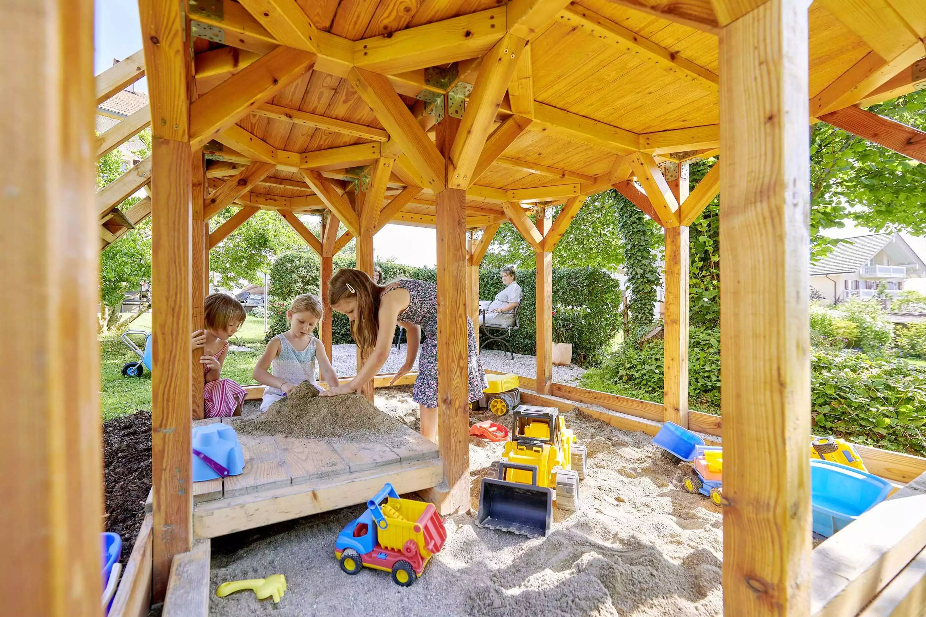 Hauseigener Spielplatz mit Spielhaus, Sandkasten, Rutsche und Schaukel
