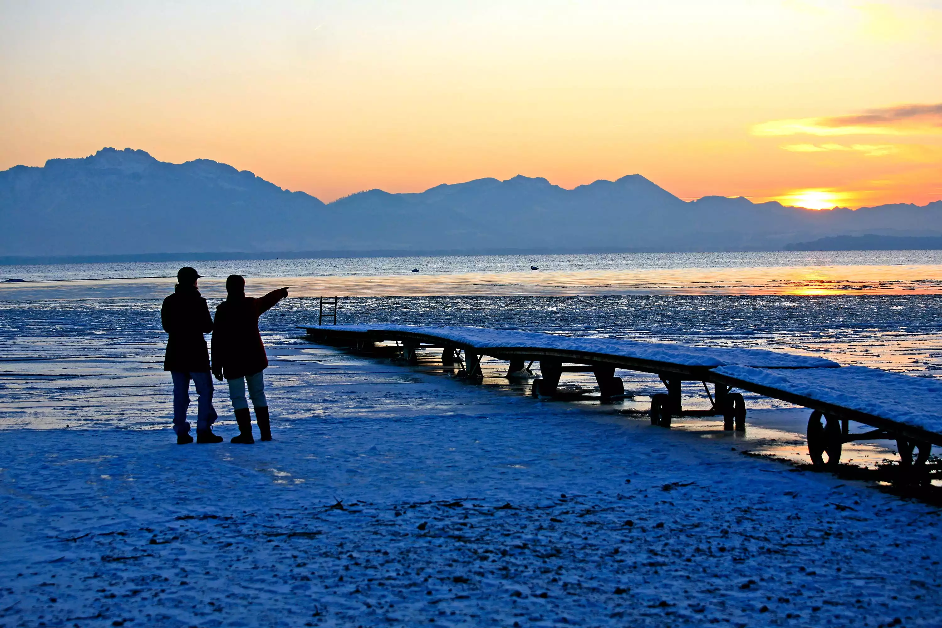 Schlittschuh laufen am zugefrorenen Chiemsee im Winter in Bayern