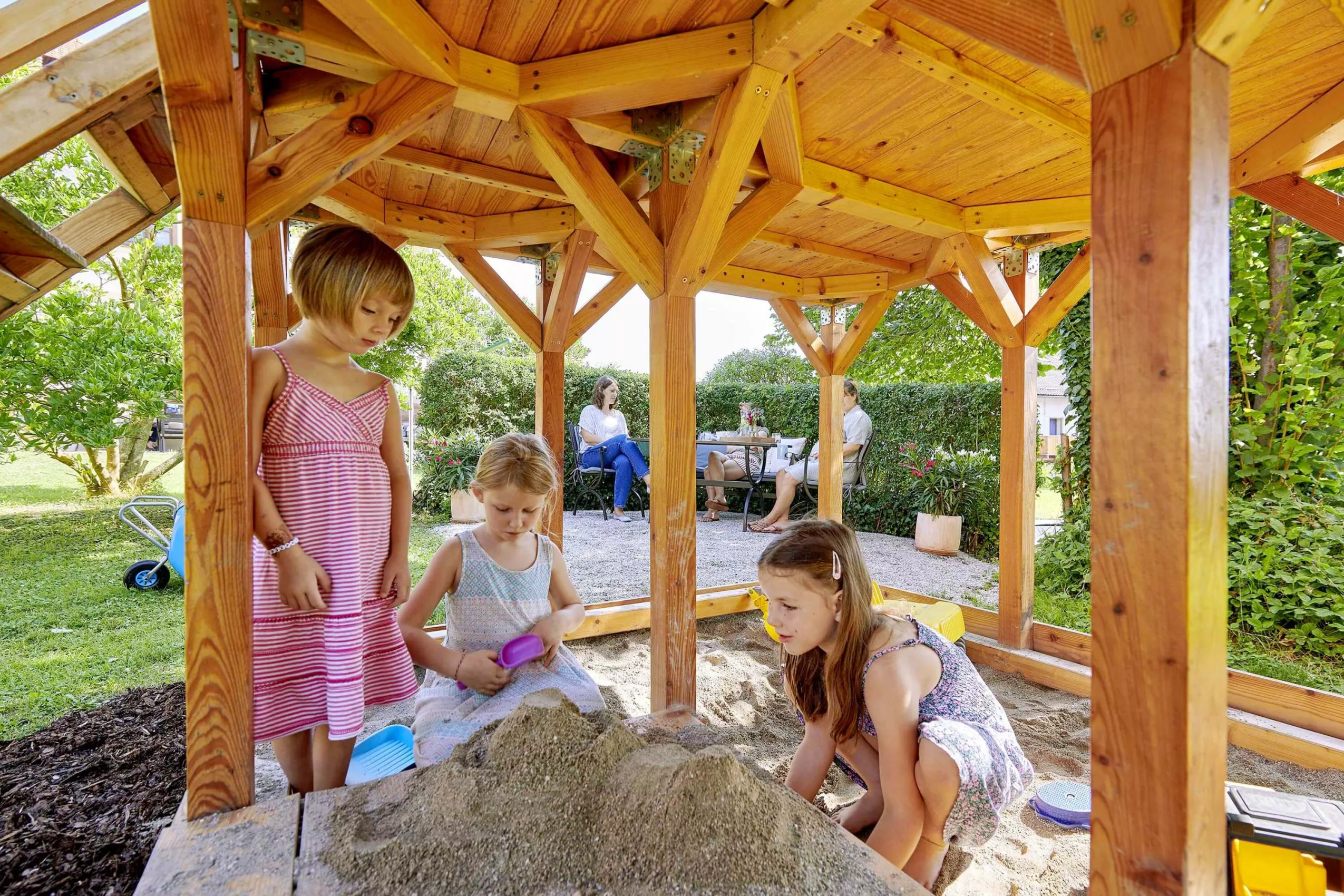 Buddeln im Sandkasten Überdachter Sandkasten am Spielplatz