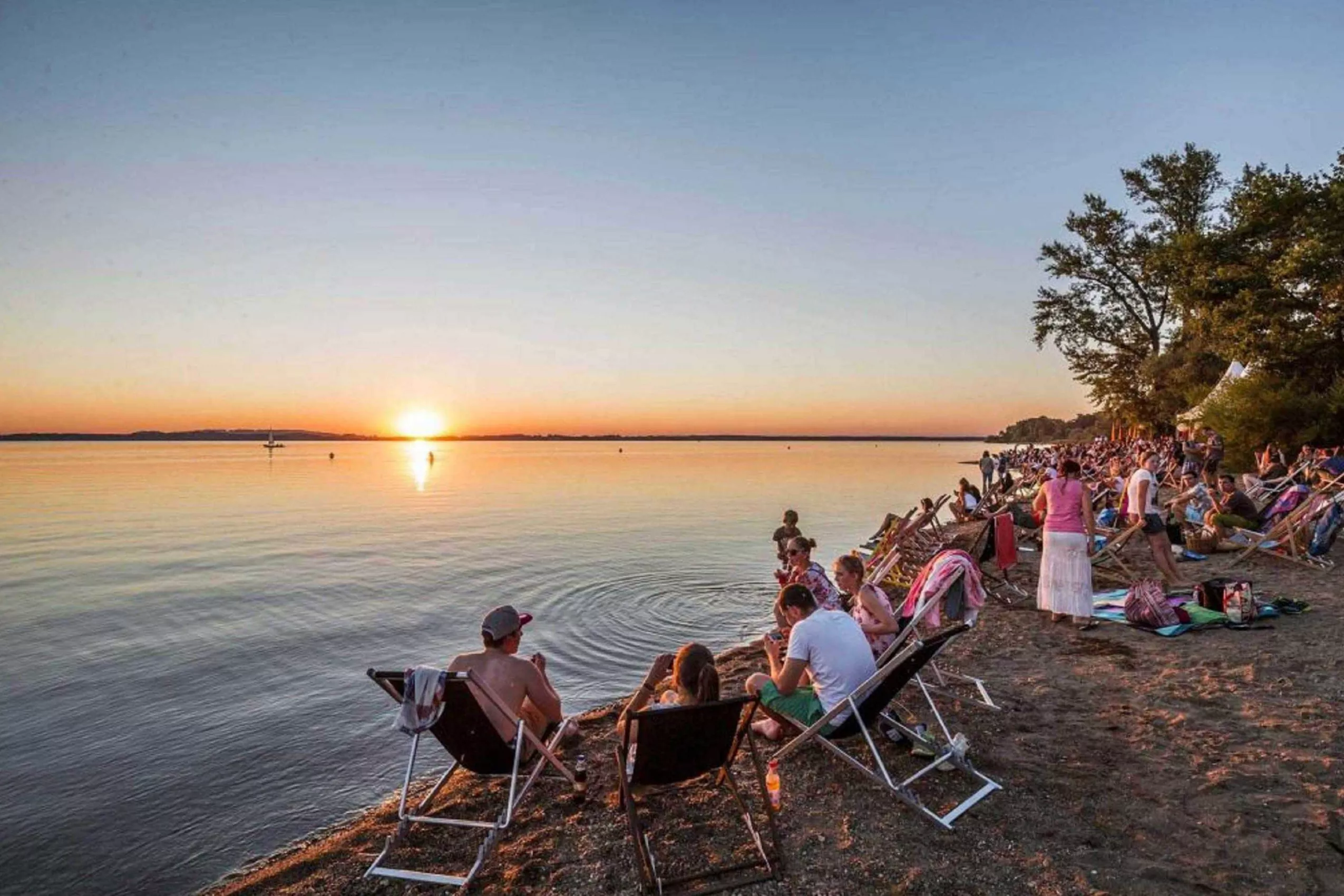 Sundowner am Strand Abendrot genießen beim romantischen Abend am Chiemsee in der Beachbar mit Cocktail